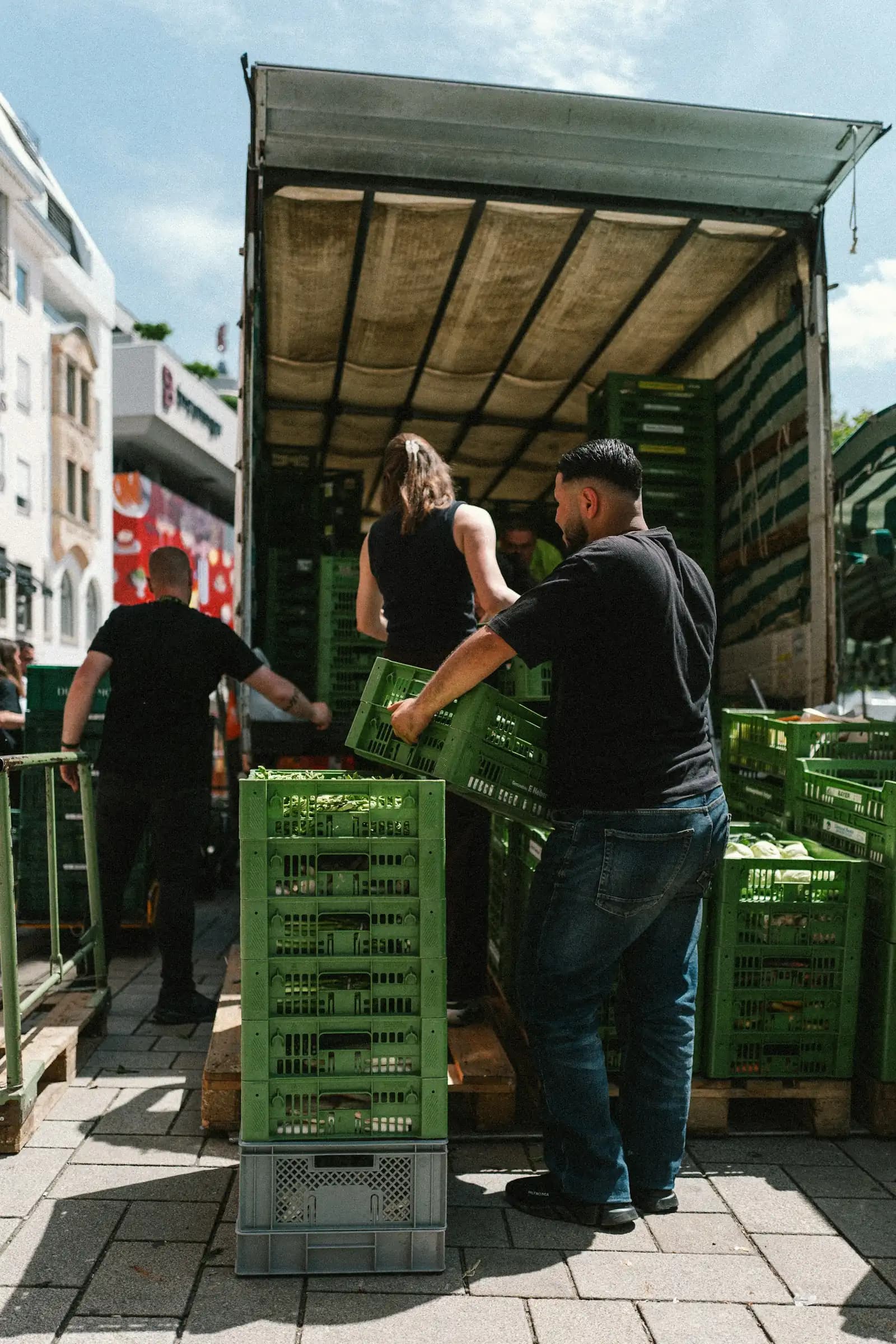 Livreurs qui déchargent des caisses de légumes d’un camion