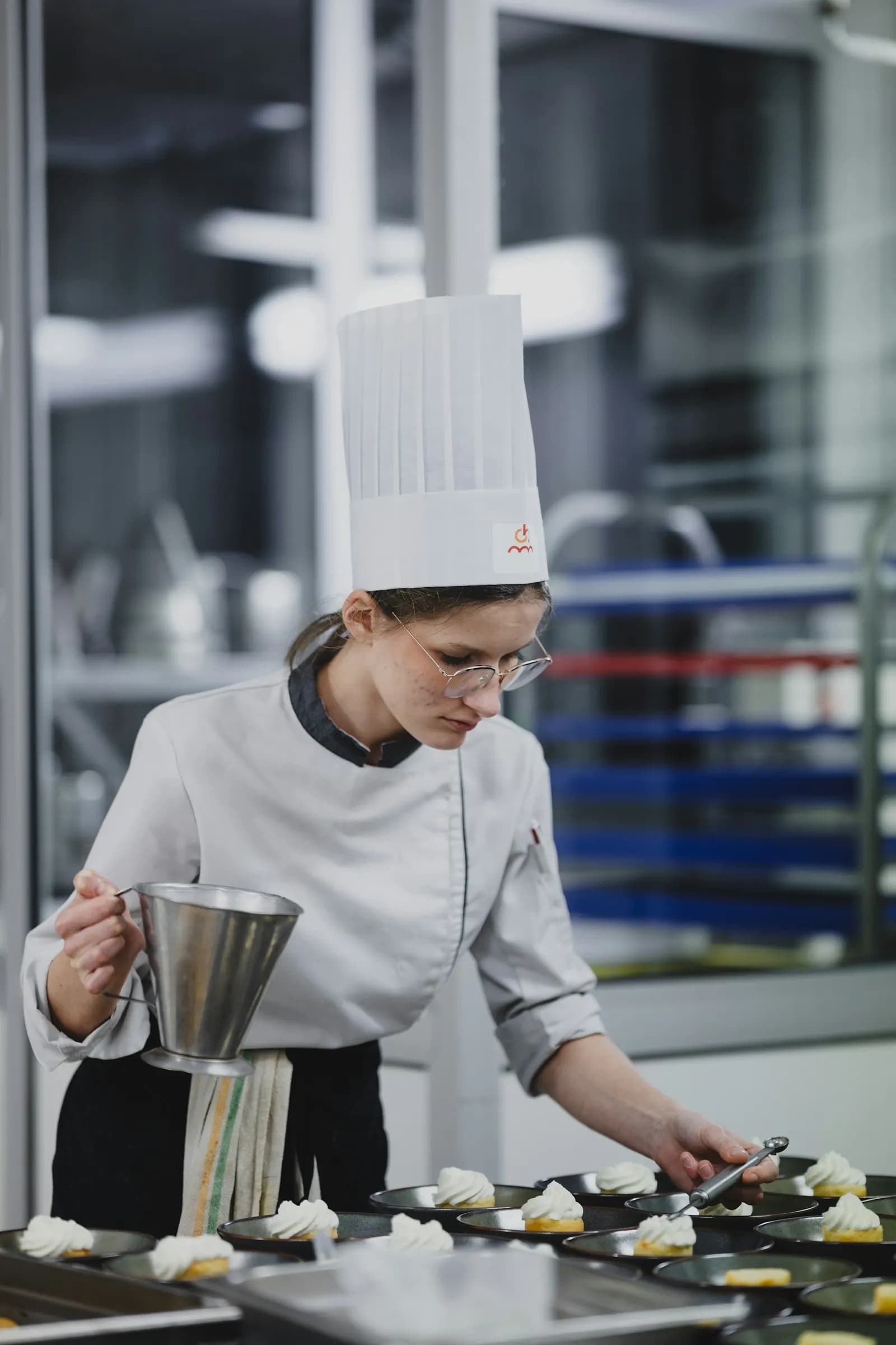 Pâtissière qui dresse des desserts en laboratoire