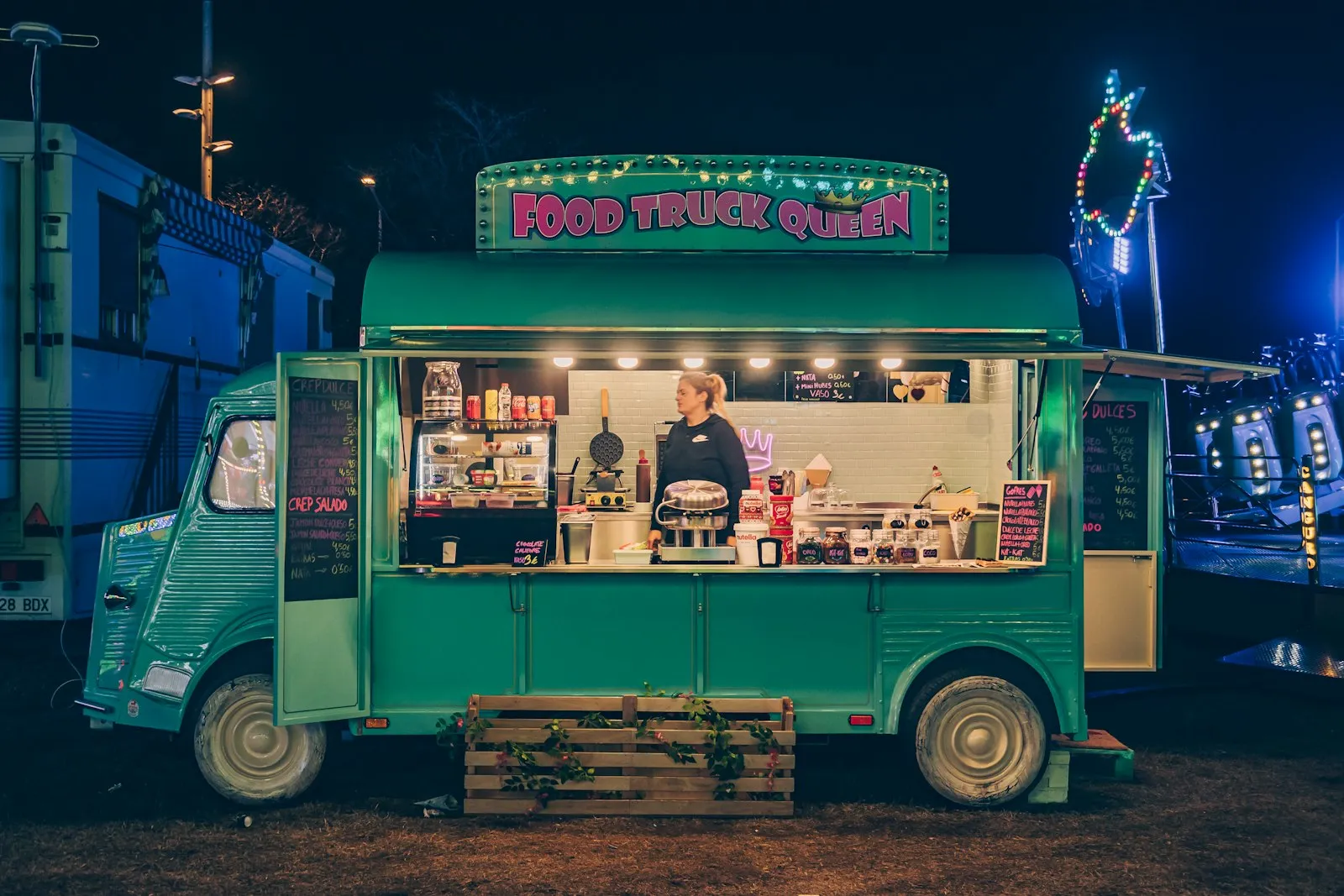 Un food truck vert éclairé le soir, le cuisinier au comptoir